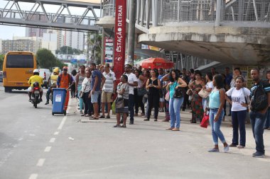 Salvador, Bahia, Brezilya - 25 Nisan 2019: Salvador kentindeki bir otobüs durağında toplu taşıma kullanıcıları görülüyor.