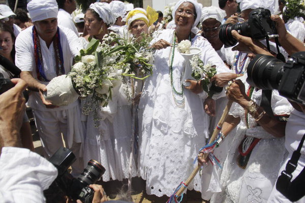 salvador, bahia, brazil - january 15, 2015: baiana washes with scented water at the entrance of Igreja do Senhor do Bonfim in the city of Salvador.