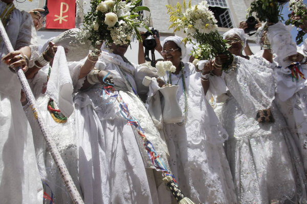 salvador, bahia, brazil - january 15, 2015: baiana washes with scented water at the entrance of Igreja do Senhor do Bonfim in the city of Salvador.