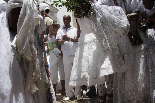 salvador, bahia, brazil - january 15, 2015: baiana washes with scented water at the entrance of Igreja do Senhor do Bonfim in the city of Salvador.