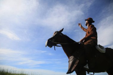conde, bahia, brasil - january 8, 2022: Cowboy wearing traditional leather clothes with his horse on a farm in the city of Conde.