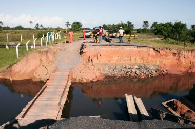 Prado, Bahia, Brezilya - 7 Nisan 2010: Prado şehrindeki bir nehrin taşması sonucu yıkılmış bir yolu geçmeye çalışan insanlar
