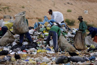 Alagoinhas, Bahia, Brezilya - 2 Mayıs 2019: İnsanlar Alagoinhas kentindeki hijyenik atık sahasının çöpleri arasında geri dönüşüm için malzeme toplarken görülüyor.