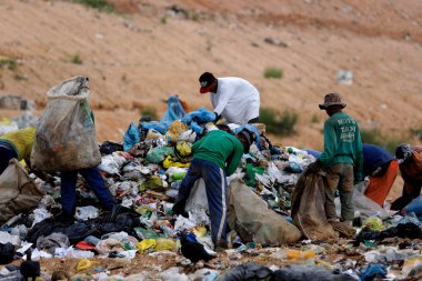 Alagoinhas, Bahia, Brezilya - 2 Mayıs 2019: İnsanlar Alagoinhas kentindeki hijyenik atık sahasının çöpleri arasında geri dönüşüm için malzeme toplarken görülüyor.
