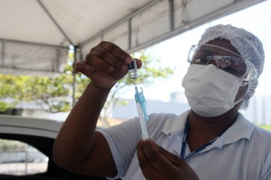 Salvador, Bahia, Brezilya - 3 Şubat 2022: Sağlık Bakanlığı 'ndan hemşire teknisyeni, Salvador şehrindeki bir hastaya uygulanacak olan Corna virüsüne karşı Pfizer aşısını hazırladı.