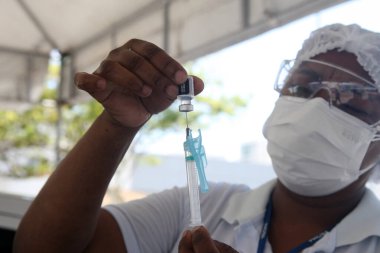 Salvador, Bahia, Brezilya - 3 Şubat 2022: Sağlık Bakanlığı 'ndan hemşire teknisyeni, Salvador şehrindeki bir hastaya uygulanacak olan Corna virüsüne karşı Pfizer aşısını hazırladı.