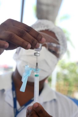 Salvador, Bahia, Brezilya - 3 Şubat 2022: Sağlık Bakanlığı 'ndan hemşire teknisyeni, Salvador şehrindeki bir hastaya uygulanacak olan Corna virüsüne karşı Pfizer aşısını hazırladı.