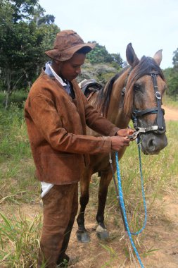 Conde, Bahia, Brezilya - 9 Ocak 2022: Kovboy, Conde şehrindeki bir çiftlikte atıyla geleneksel deri giysiler giyiyor.