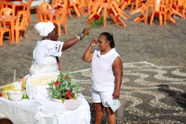 Salvador, Bahia, Brezilya - 25 Ocak 2015: Candomble adept, Salvador şehrinde dini bir gösteri sırasında bir rahibeden ruhani bir banyo alır..