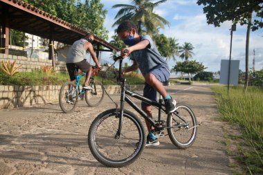 Salvador, Bahia, Brezilya - 27 Ocak 2022: Salvador 'da Metropolitando de Pituacu' da bisiklet yolunda bisiklet süren baba ve oğul.