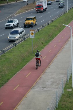 Salvador, Bahia, Brezilya - 31 Ocak 2022: Salvador 'da Avenida Luiz Viana' da araç trafiğinin yanında bisiklet yolu