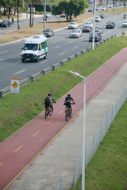 Salvador, Bahia, Brezilya - 31 Ocak 2022: Salvador 'da Avenida Luiz Viana' da araç trafiğinin yanında bisiklet yolu
