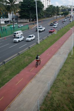 Salvador, Bahia, Brezilya - 31 Ocak 2022: Salvador 'da Avenida Luiz Viana' da araç trafiğinin yanında bisiklet yolu