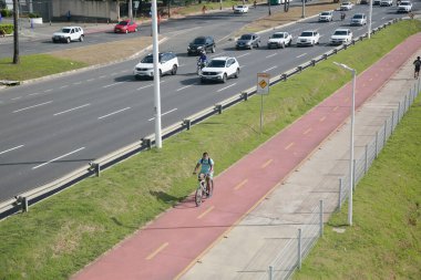 Salvador, Bahia, Brezilya - 31 Ocak 2022: Salvador 'da Avenida Luiz Viana' da araç trafiğinin yanında bisiklet yolu
