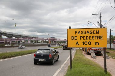 Salvador, Bahia, Brezilya - 11 Nisan 2022: BR 324 karayolundaki trafik levhası 100 metre ötede yaya geçidi olduğunu gösteriyor..