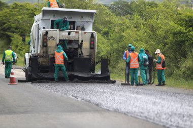 ipira, bahia, brezil- 17 Mayıs 2022: Bahia 'daki BA 052 otobanındaki asfalt kaldırımını işçi onardı.