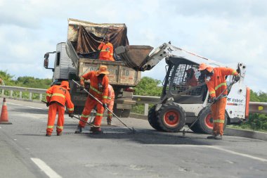 ipira, bahia, brezil- 17 Mayıs 2022: Bahia 'daki BA 052 otobanındaki asfalt kaldırımını işçi onardı.