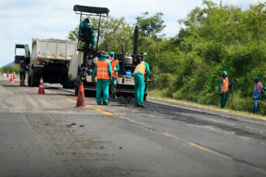 ipira, bahia, brezil- 17 Mayıs 2022: Bahia 'daki BA 052 otobanındaki asfalt kaldırımını işçi onardı.
