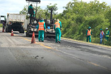 ipira, bahia, brezil- 17 Mayıs 2022: Bahia 'daki BA 052 otobanındaki asfalt kaldırımını işçi onardı.