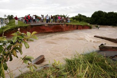 Prado, Bahia, Brezilya - 7 Nisan 2010: Prad şehrinde sel baskını nedeniyle sel basmış bir nehri geçmek için kano kullanan insanlar