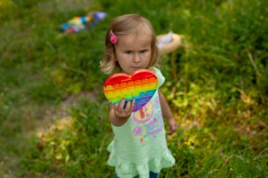 Oyuncaklı küçük kız onu yeşil çimlerin arkasına koy..