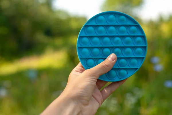 Azzurro Pop Cerchio Nella Mano Della Donna Sullo Sfondo Erba — Foto Stock