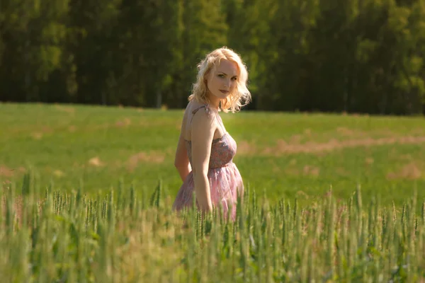 Беременная девушка, стоящая в поле — стоковое фото
