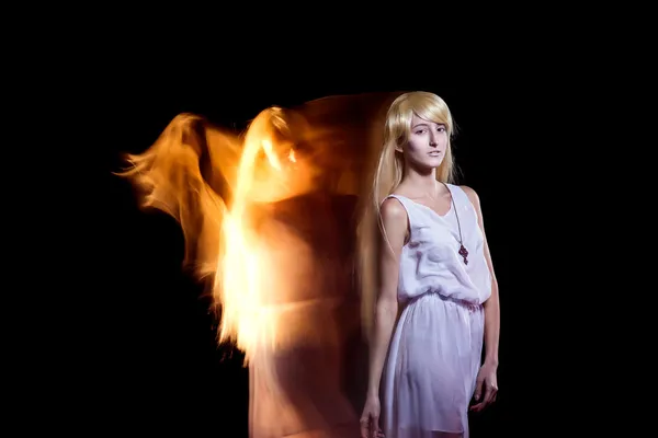 Behind the beautiful young girl with a fair hair the fiery angel — Stock Photo, Image
