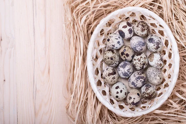 Kwartel eieren in een mand op houten tafel, bovenaanzicht — Stockfoto