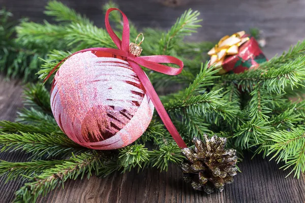 Červená vánoční koule s větve stromu jedle na dřevěné pozadí — Stock fotografie