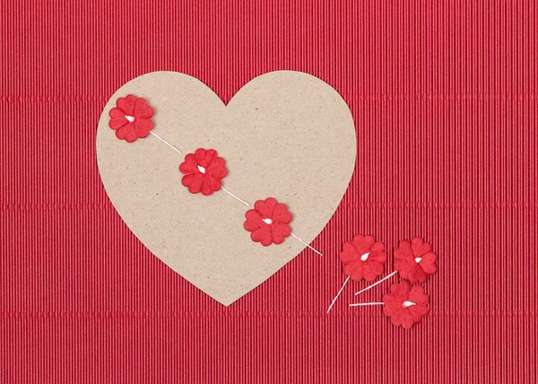 Kağıt çiçekler kırmızı zemin üzerine karton kalp — Stockfoto