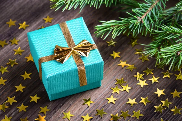 Regalo de Navidad con estrellas y rama de abeto en la mesa de madera — Foto de Stock