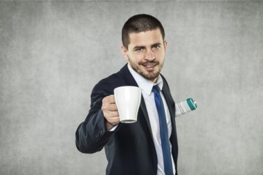 İş adamı elinde bir fincan kahve tutuyor.