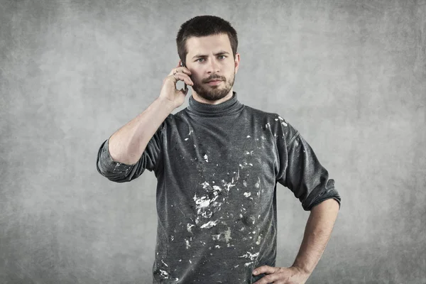 Jeune homme en vêtements de travail parlant au téléphone — Photo
