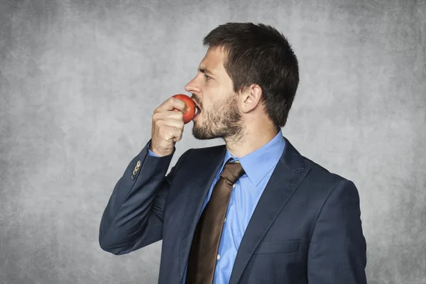 Hombre de negocios comiendo una manzana — Foto de Stock