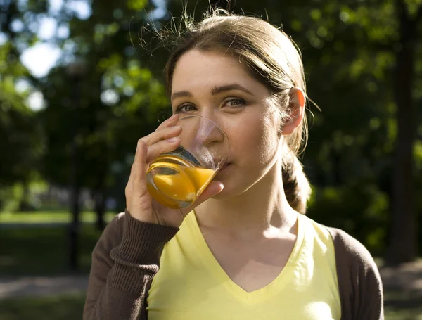 Portrait of pretty young woman drinking juice, healthy lifestyle