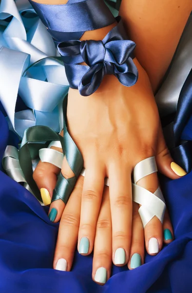 blue manicure with ribbon close up