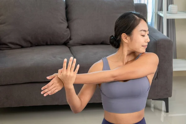 Asian people practicing yoga lifestyle class on a mat at living room. Young women with sports ware teach how to exercise yoga training at hom