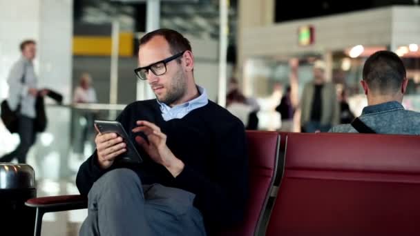 Biznesmen za pomocą tabletki na lotnisku — Wideo stockowe
