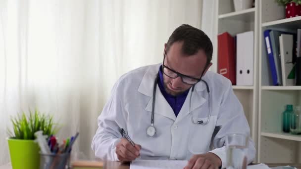 Dokter die met documenten werkt — Stockvideo