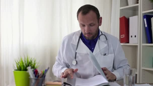 Male doctor reading patients cards — Stock Video