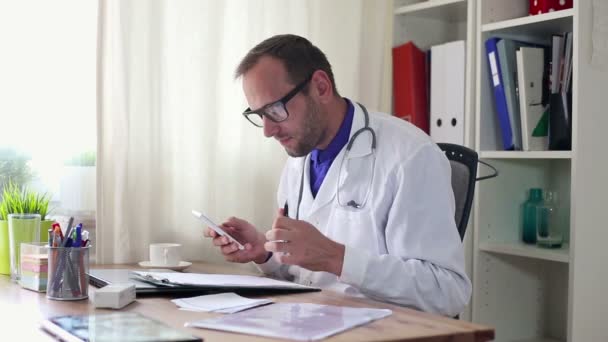 Doctor with smartphone and documents — Stock Video