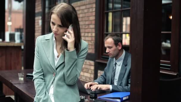 Занятая деловая женщина разговаривает по мобильному телефону — стоковое видео