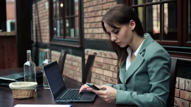 Ung affärskvinna arbetar med smartphone och laptop — Stockvideo