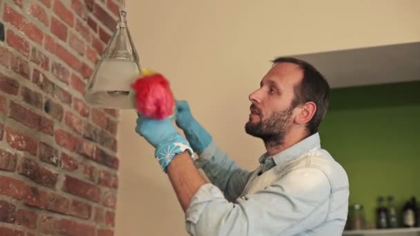 Man cleaning lamp with duster — Stock Video