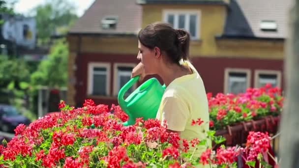 Mujer regando flores en balcón — Vídeo de stock