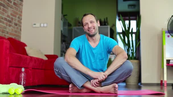 Homem sentado no tapete de exercício — Vídeo de Stock
