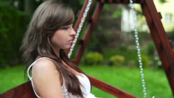 女人坐在长椅上的秋千 — 图库视频影像