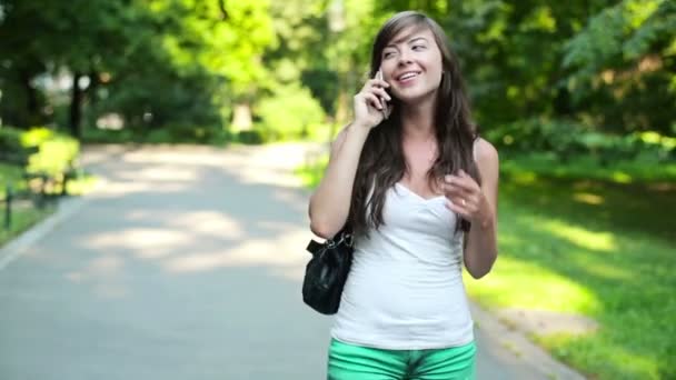 Vrouw praten op mobiele telefoon in het park — Stockvideo