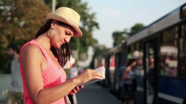 Kobieta czytająca książkę na przystanek autobusowy — Wideo stockowe